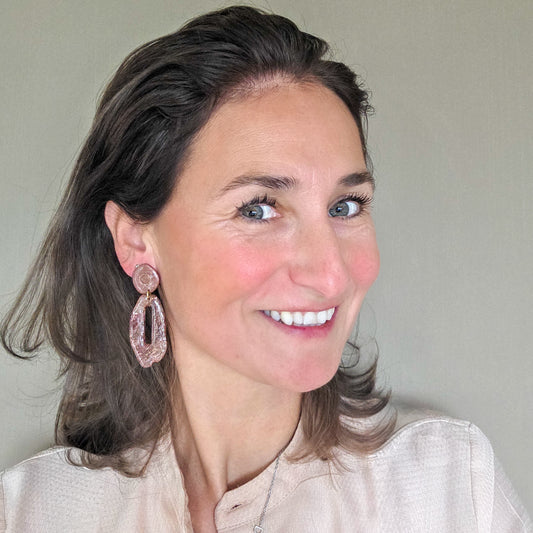 vrouw draagt lange bruine oorbellen met goudspikkel