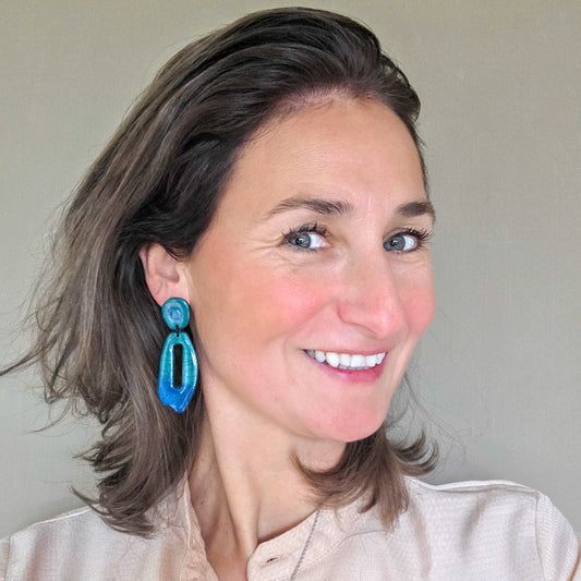 vrouw draagt lange blauw met groene metallic oorbellen