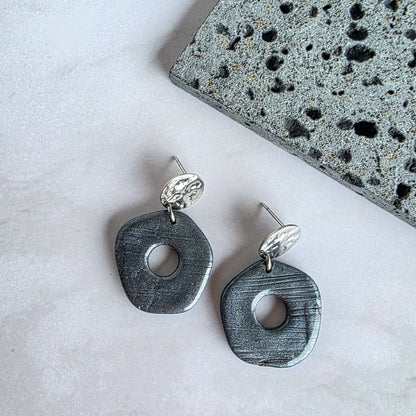 Kleine grijze organische oorbel met zilverkleurig oorknopje