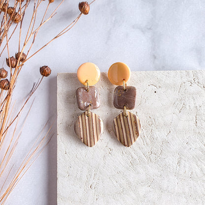 Gestreepte handgemaakte exclusieve oorbel met bruin, oranje en gele accenten