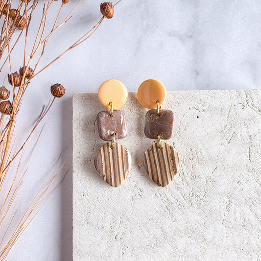 Gestreepte handgemaakte exclusieve oorbel met bruin, oranje en gele accenten