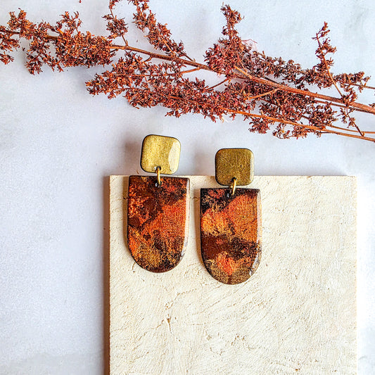 Unieke handgemaakte hoekige oorbellen in goud, oranje en bruin, gemaakt van polymeerklei – Handmade Elegance by Delfine