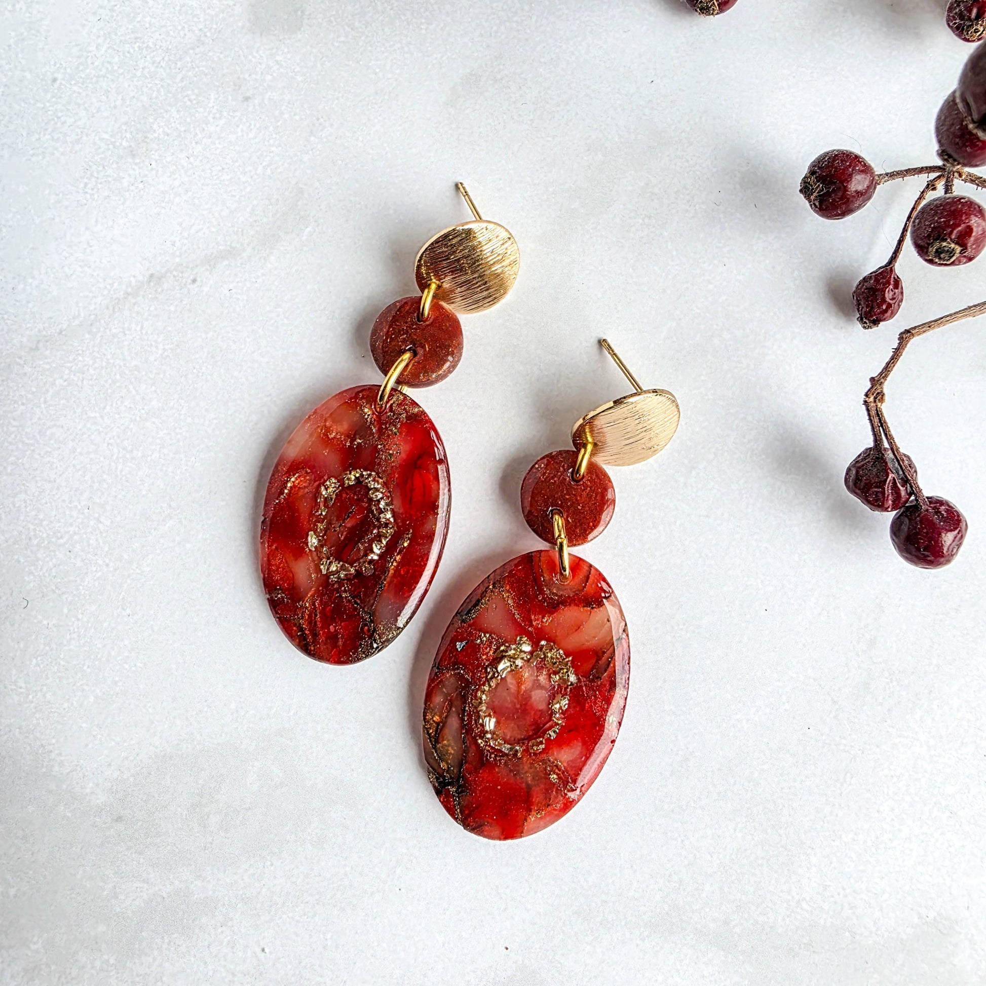 Stijlvolle ovalen oorbellen van polymeerklei in steenrood met goud, uniek en handgemaakt – Handmade Elegance by Delfine