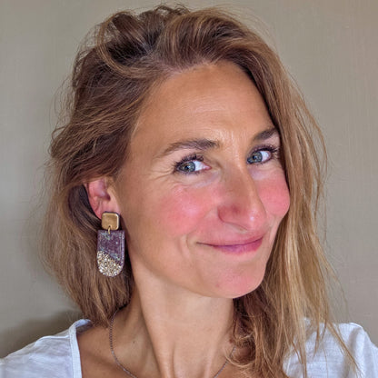 Handgemaakte lange oorbellen in paars taupe met brons, gedragen aan het oor – Handmade Elegance by Delfine