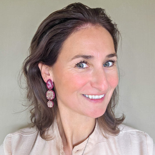 vrouw draagt feestelijke burgundy red oorbellen met druppelvormige stud met rosé goud crushed glass