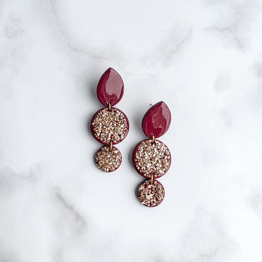 lange burgundy red oorbellen met rose roze crashed glass op wit grijs marmeren blad