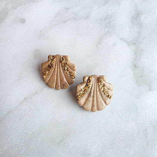 korte studs in schelpvorm met gouden crashed glass oorbellen op wit grijs marmeren blad