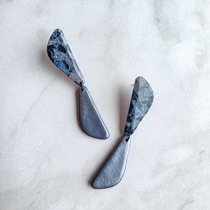 lange koel blauwe oorbellen op wit grijs marmeren blad